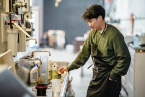 Cook looking at sink because he needs a Houston restaurant plumber for maintenance