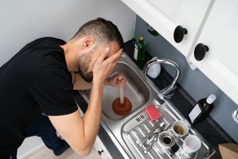 Person trying to clear clogged sink drain and needs help from a Houston multi-family plumbing contractor